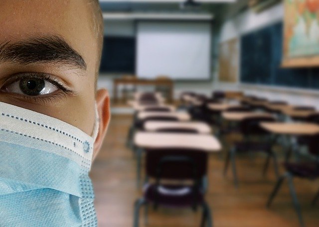 child wearing face mask in empty classroom