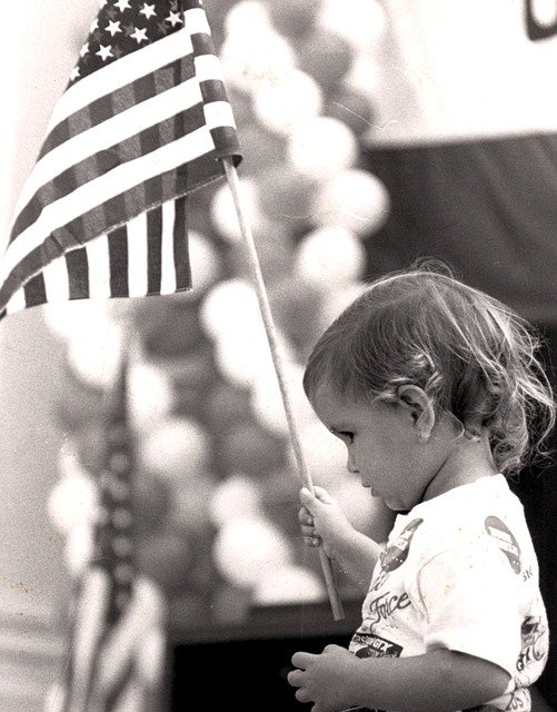 Toddler holding American flag
